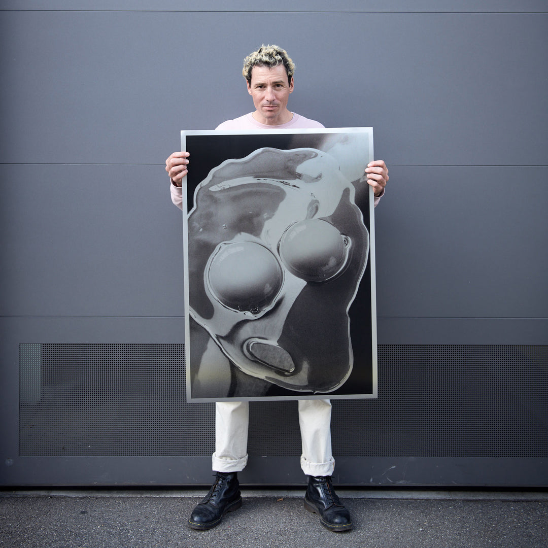artist and photographer Peter Hauser holding his silkscreen print poster